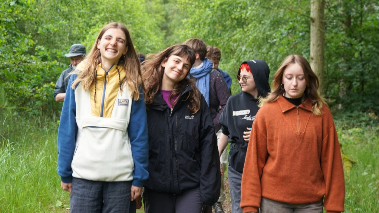 Junge Menschen lachen und laufen im Wald